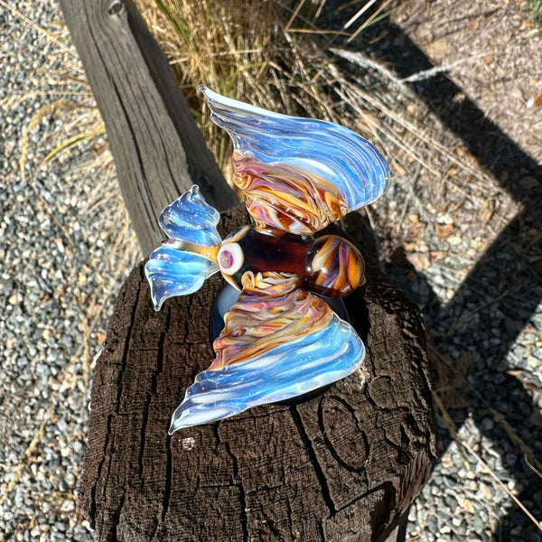 This is the Glass Soaring Hawk Sculpture by Biting Glass available at Ritual Colorado. A stylish borosilicate glass sculpture featuring a hawk soaring with wings out attached to a dark blue base with subtle "clouds".