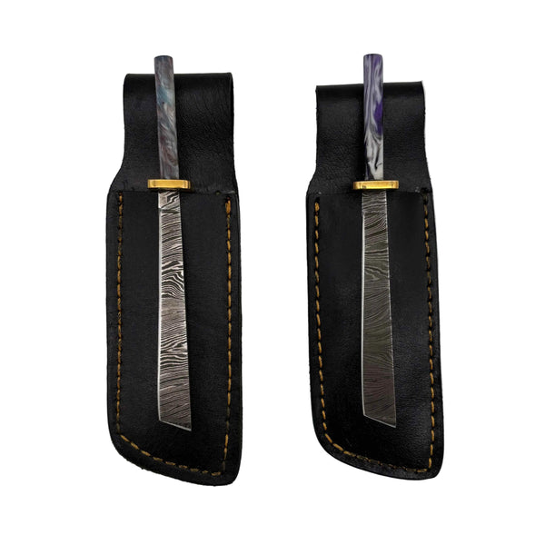 These are damascus steel Straight Katana dab tools from Dabmascus available at Ritual Colorado. Featuring intricate steel patterns on the blade accented by handmade handles with vibrant swirling colors.