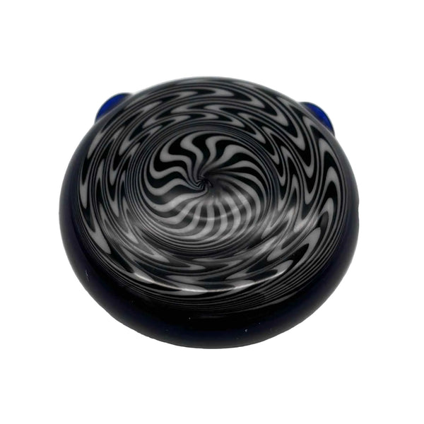 This is the hypnotizing Black & White Swirl Disc Pendant by Biting Glass available at Ritual Colorado. Featuring an intricate black & white pattern accented by deep blue glass on the back this is a bold and stylish jewelry piece.