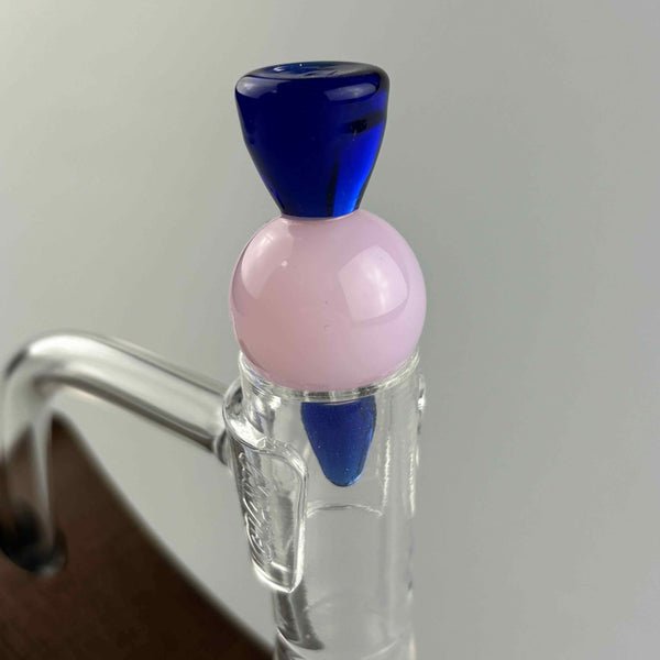 These are Solid Spike Carb Caps by Biting Glass available at Ritual Colorado. Featuring a 21mm marble in the center with a flared handle on top and airflow disrupting spike on bottom.