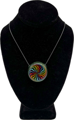 This is the vibrant Rainbow Swirl Disc Pendant by Biting Glass available at Ritual Colorado. Featuring an intricate color pattern accented by sparkle green glass on the back this is a bold and stylish jewelry piece.
