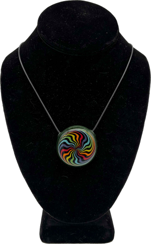This is the vibrant Rainbow Swirl Disc Pendant by Biting Glass available at Ritual Colorado. Featuring an intricate color pattern accented by sparkle green glass on the back this is a bold and stylish jewelry piece.