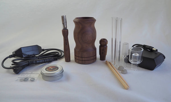 This is Ed's TnT WoodScents AromaLog shown in Walnut wood available at Ritual. The full kit is pictured including power cord and adapter, glass stems, glass water pipe adapter, glass aroma bowl, o-rings, Walnut stem and water pipe adapter, screens, and Ed's Bomb Ass Butter.